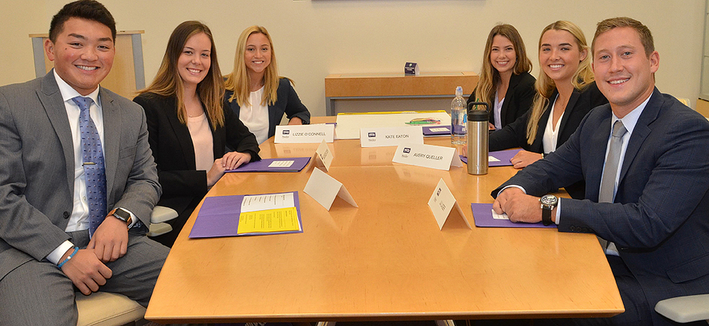 Section Image: Neeley leaders at a conference room table 