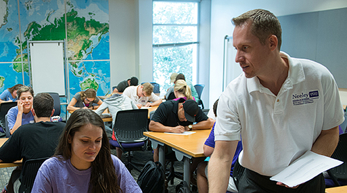 Section Image: Keith Hmieleski passing out papers to students 