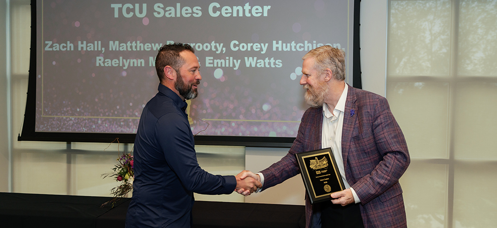 Zach Hall accepting the award from Craig Crossland for the TCU Sales Center