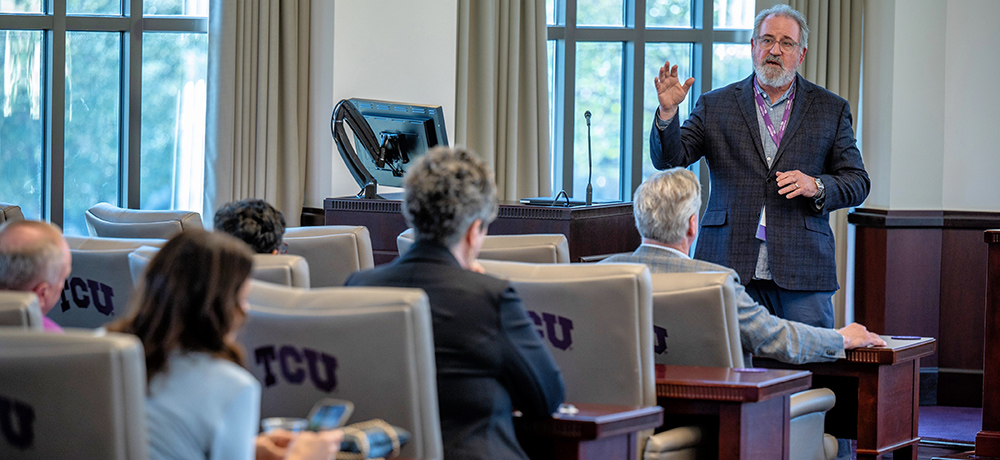 Section Image: Professor teaching in front of group 