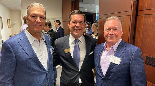 Group of three men pose at the Center for Real Estate Open House.