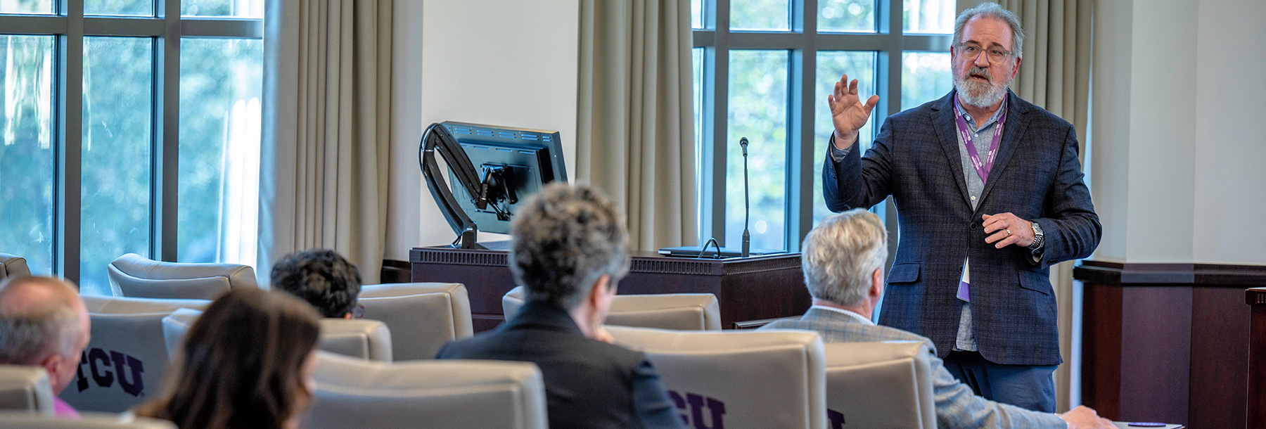 Section Image: Professor teaching in front of group 