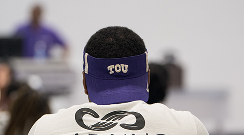 Student wearing a TCU visor. 