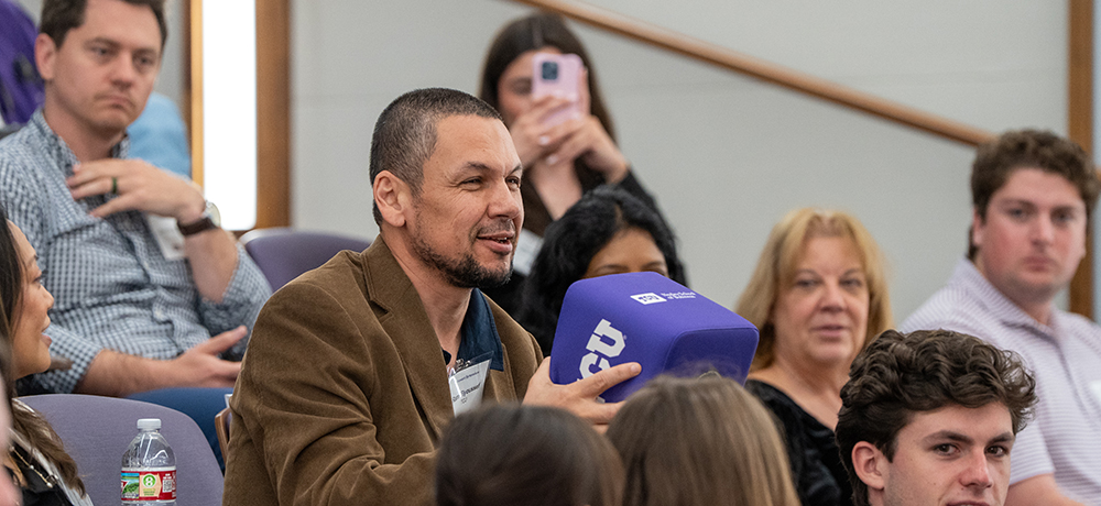 Audience member asking a question using a box mic