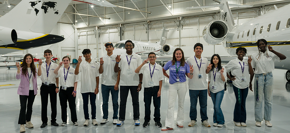 Group in hanger with airplanes