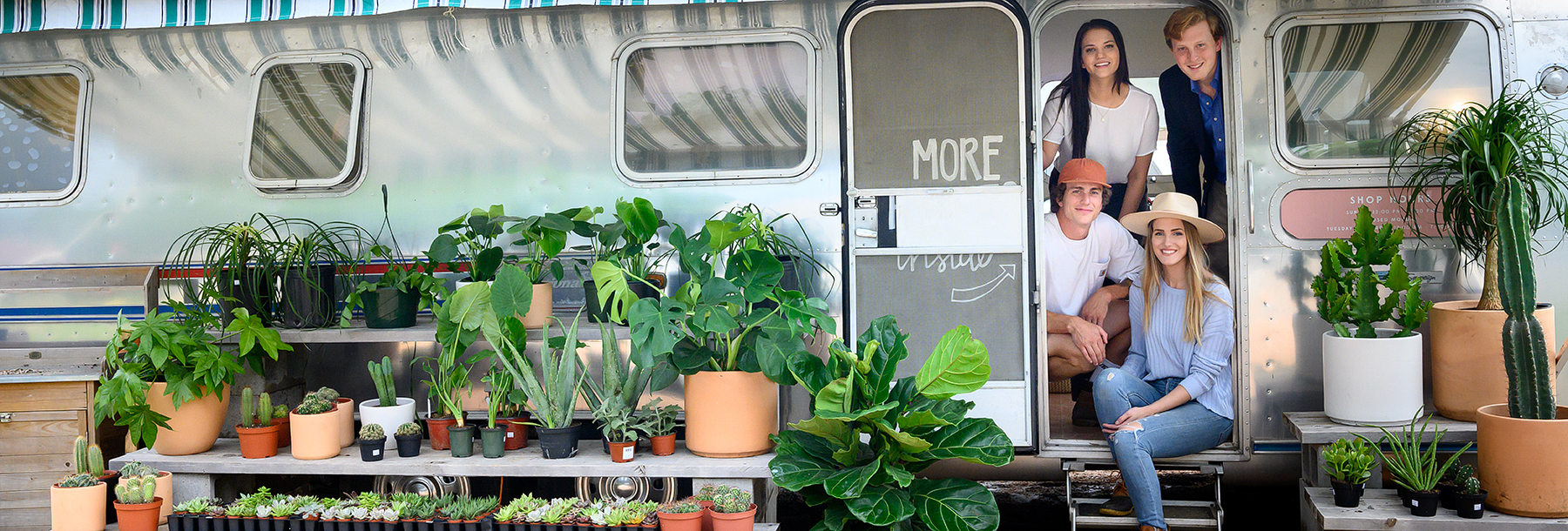 Section Image: Students in doorway of a trailer surrounded by plants 