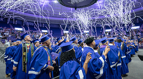 Graduates watching as confetti rains down on them 